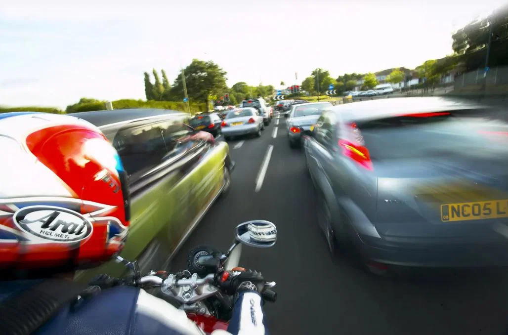 車の流れをすり抜けるバイク。