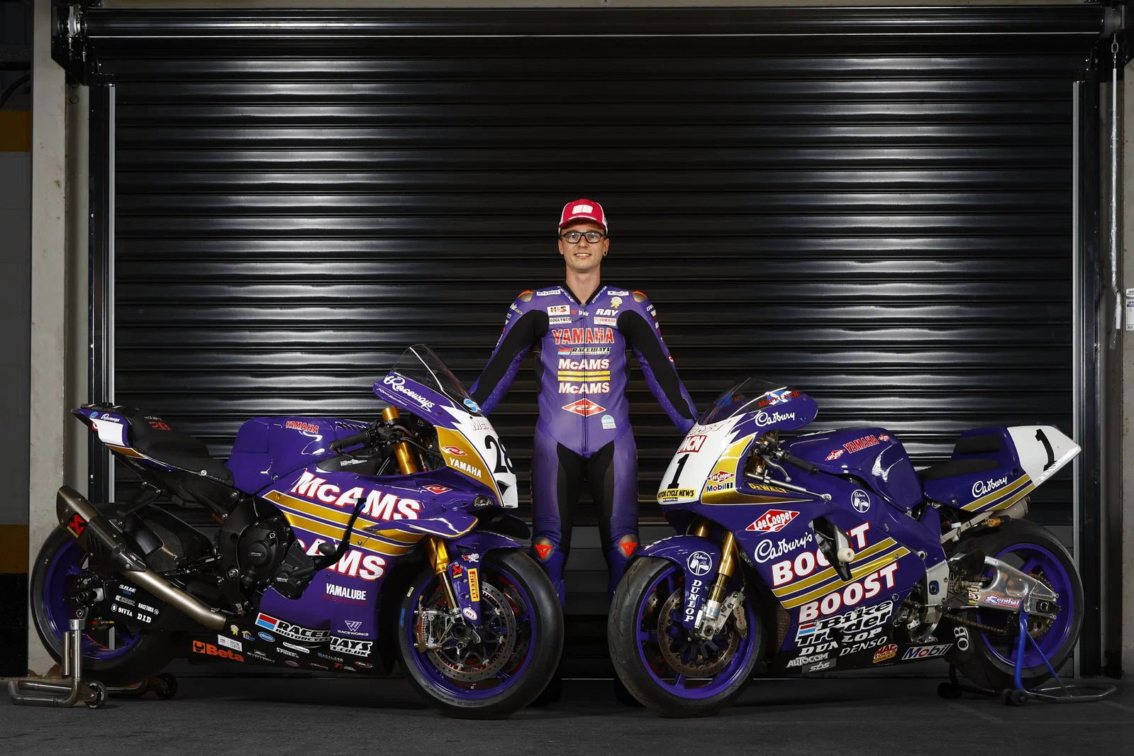 McAMS Yamaha とオリジナルの Cadbury Boost バイクとともに立っているブラッドリー レイ。